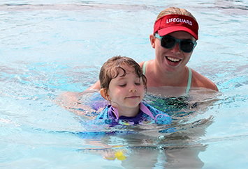 lifeguard assisting a child swimming