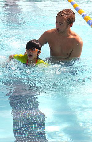 instructor holding a child as they learn to swim