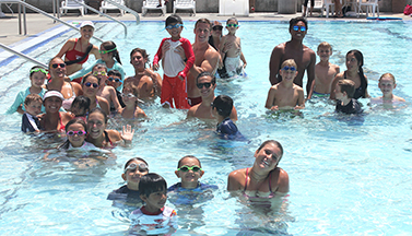 group picture of instructors and students in a pool during swim class