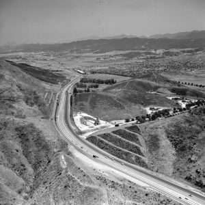 Top of the pass, Conejo Grade. Portions of old highway are visible on western side of the grade, just below junction of Old Conejo Rd. and the present southbound weigh station.  In 1970  Old Conejo still had some active quarries as well as a few homes.  Photo by Frank Knight.  LHP003769b.   There are no known U.S. copyright restrictions on this image. The Thousand Oaks Library requests that, when possible, the credit statement should read: "Image courtesy of Conejo Through the Lens, Thousand Oaks Library."