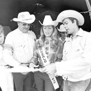 Miss Conejo Valley 1973 Patrice Barton, center, cuts the ribbon in a tent opening ceremony to mark the start of Conejo Valley Days. Miss Barton is assisted by Bill Hibbit, left (whose wife is beside him at far left), and CVD chairman George Engdahl, right. Photograph by Bob Chamberlin. News Chronicle Collection, 05-13-1973. We're happy to share this digital image on Flickr. Please note that this is a copyrighted image. For information regarding obtaining a reproduction of this image, please contact the Special Collections Librarian of the Thousand Oaks Library at specoll@tolibrary.org.
