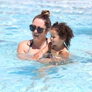 Aquatics tab: photo of a swim instructor teaching a little girl how to swim